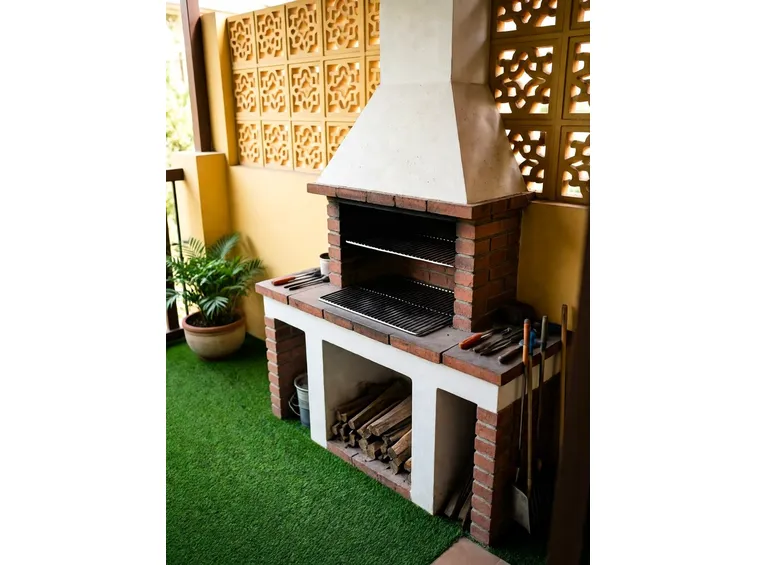 Barbecue costruito in mattoni, con due vani e cappa